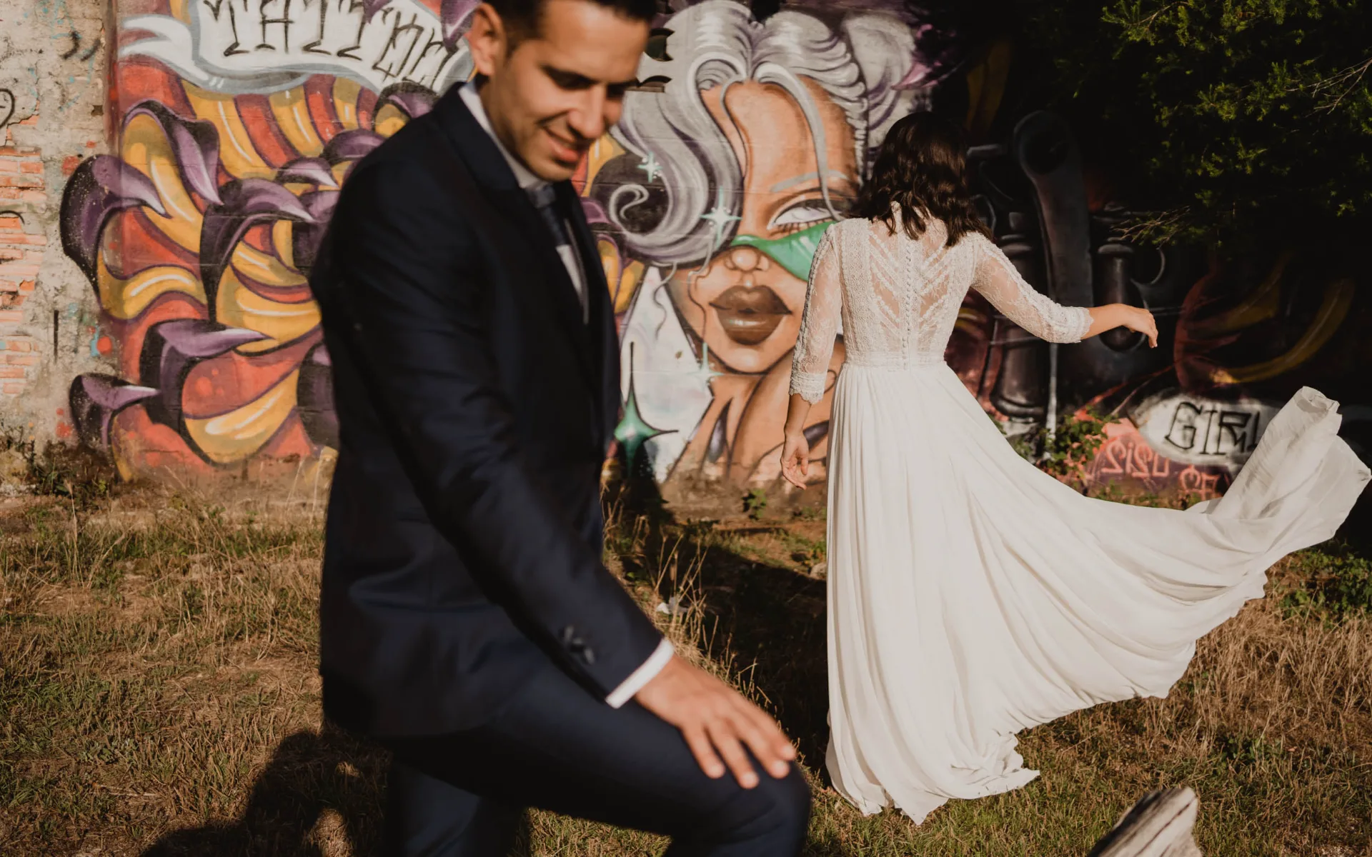 Novios posando frente a un mural de arte urbano